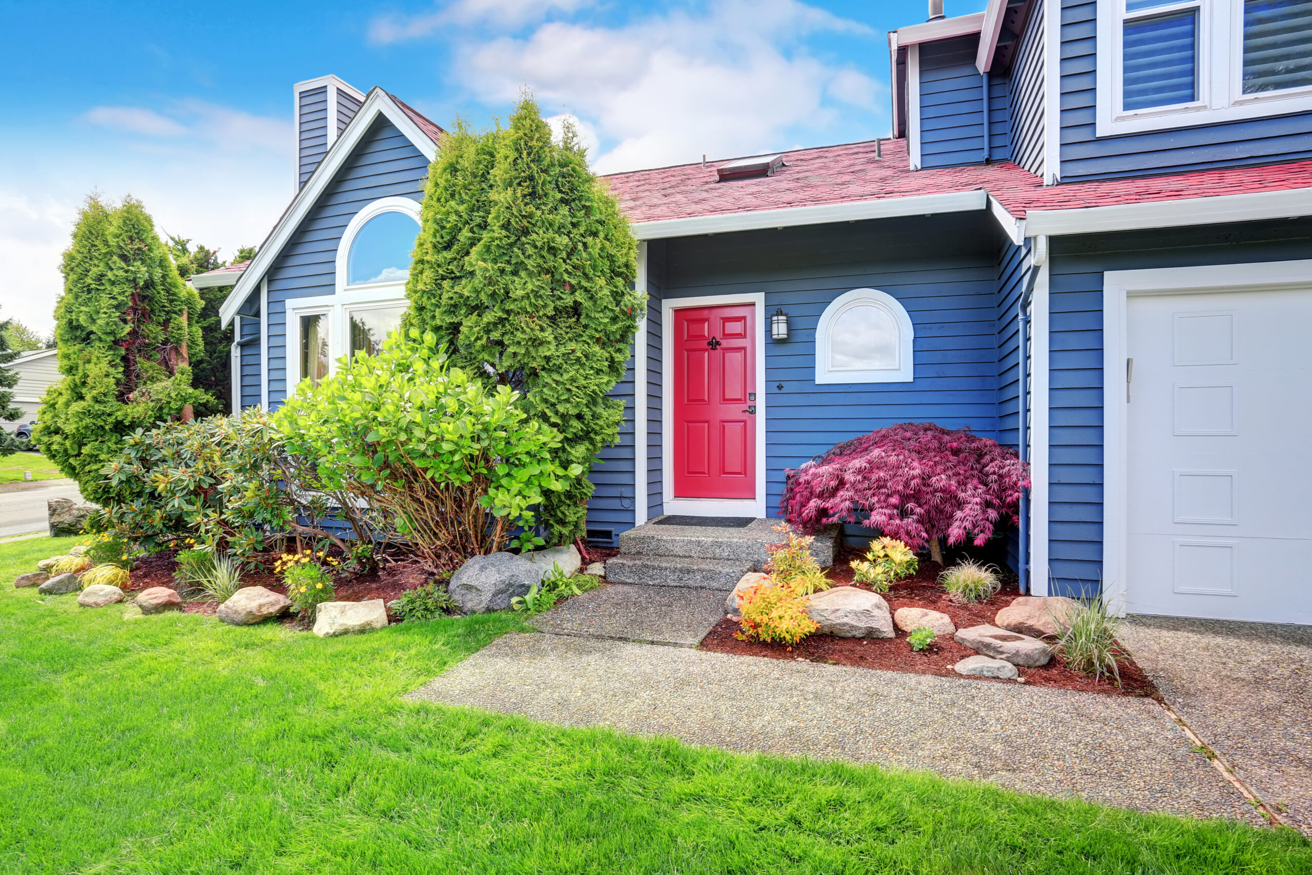 Beautiful curb appeal with blue exterior paint and red roof.