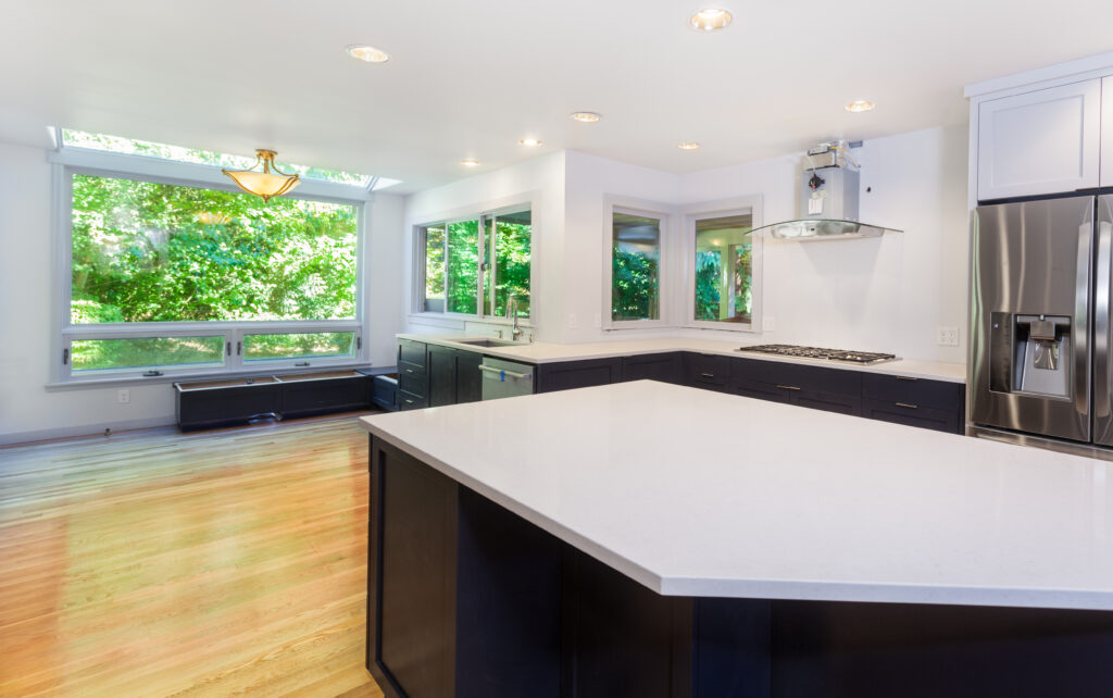 Kitchen more functional with a sink, cooktop, refrigerator and partially installed vent hood. Window seat bench bases installed