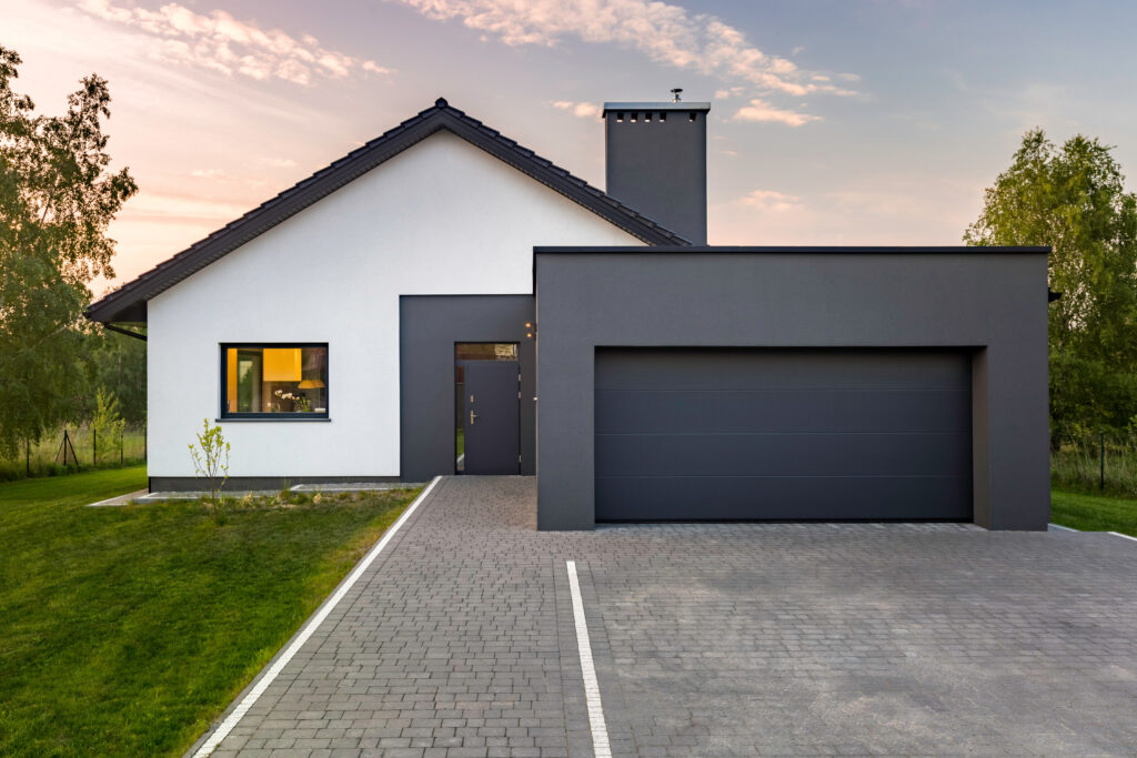 Modern house with garage and green lawn, exterior view