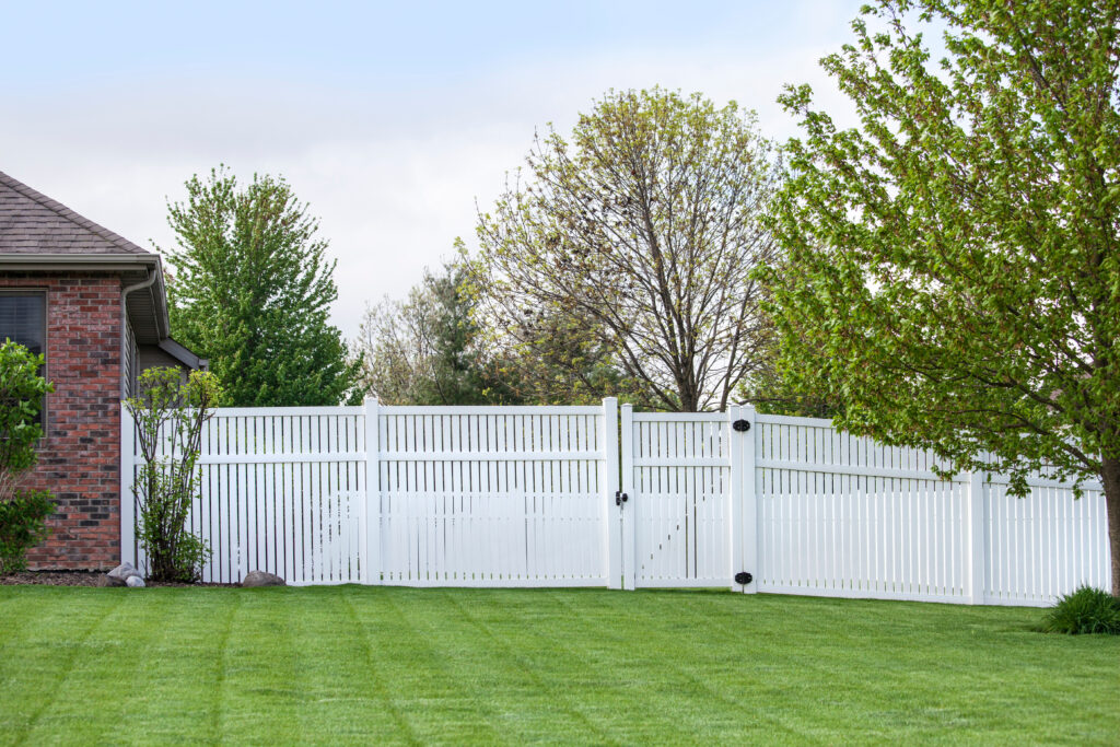 Contemporary White vinyl fence enclosing a backyard