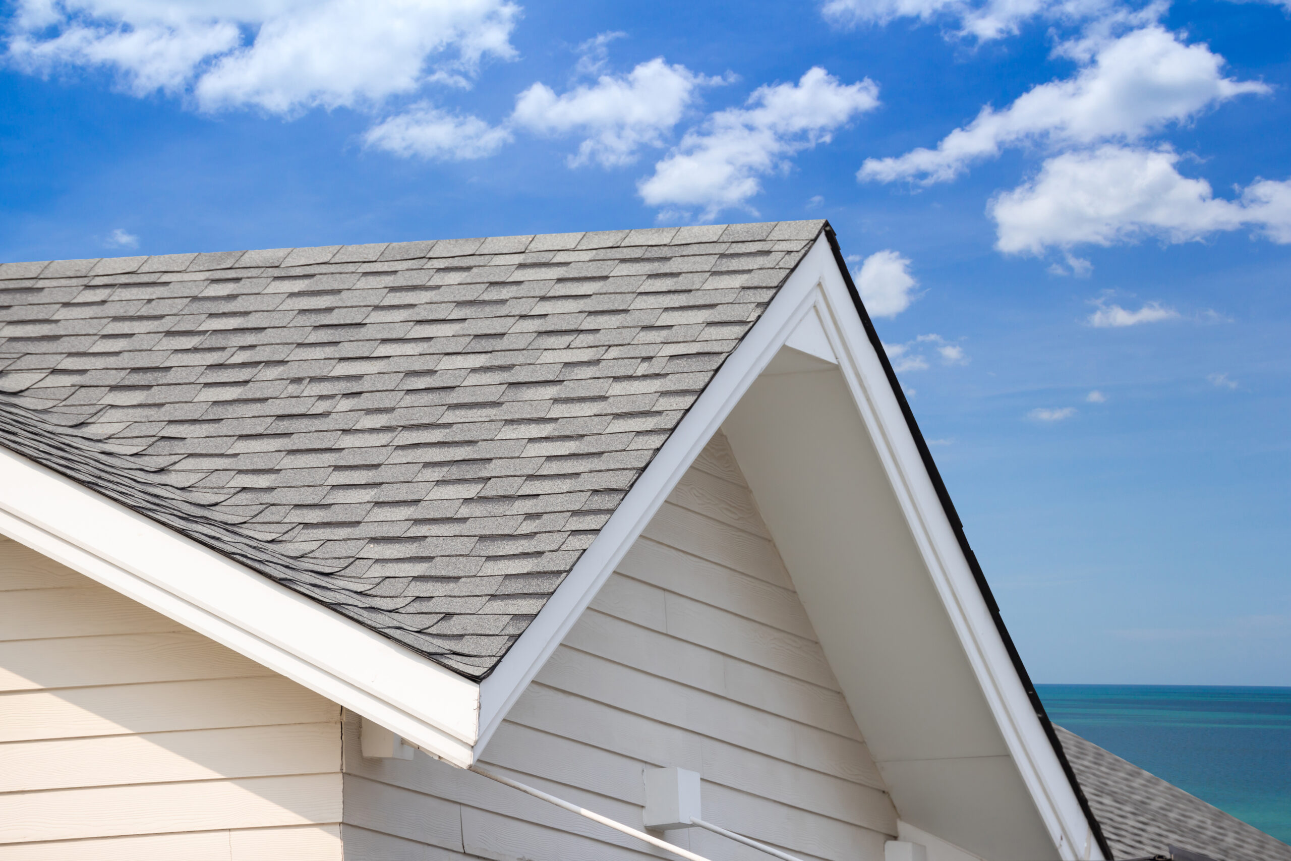 grey roof shingle with blue sky background, house roof near sea in morning time.