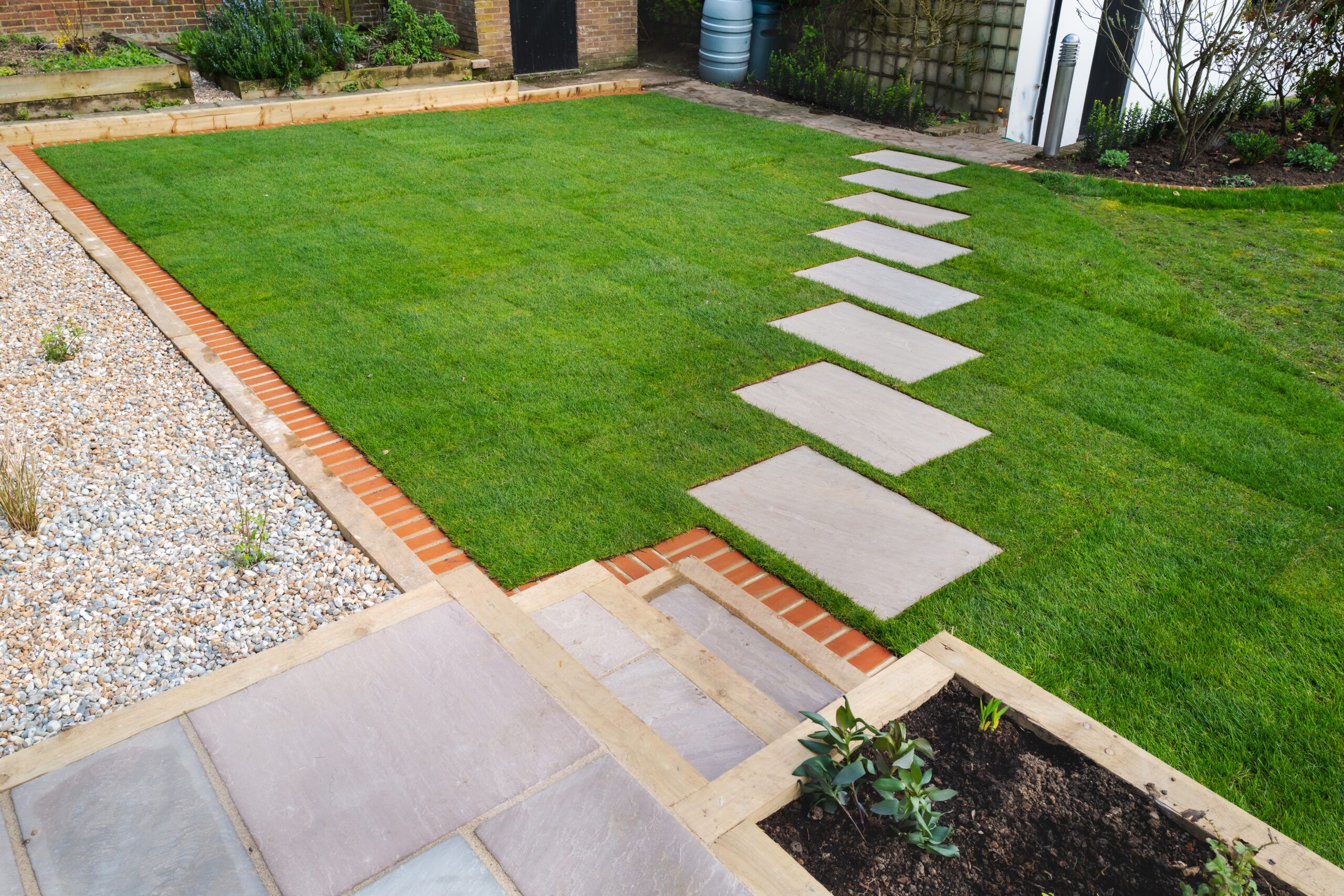 New turf installation around a new stepping stone pathway to a p