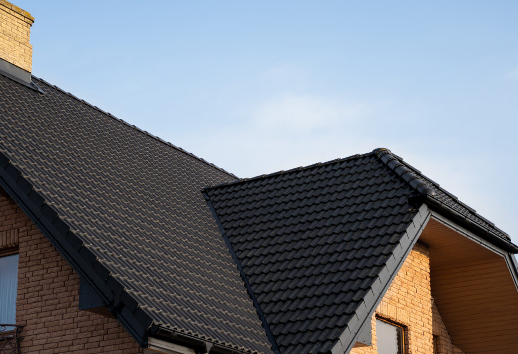 Brown metal tile roof. Roof metal sheets. Modern types of roofing materials. Roof of the house, metal roof tile against the blue sky. Building