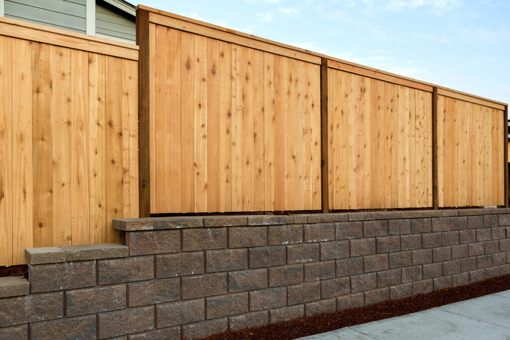 Wood Fencing on concrete stone retaining wall on sidewalk of home