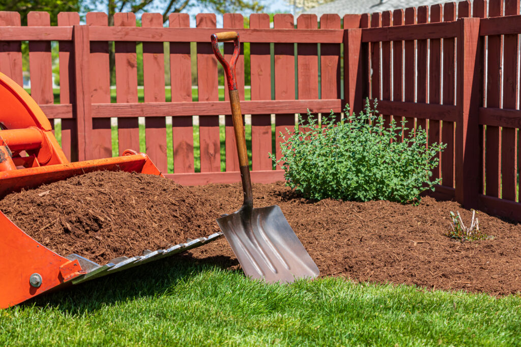 Tractor loader with wood chips or mulch and flowerbed. Lawncare,